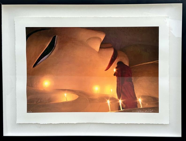 Nirvana 2 by Felice Willat Surreal scene of a robed figure standing among glowing candles beneath a large serene face in a warm, dreamlike landscape.